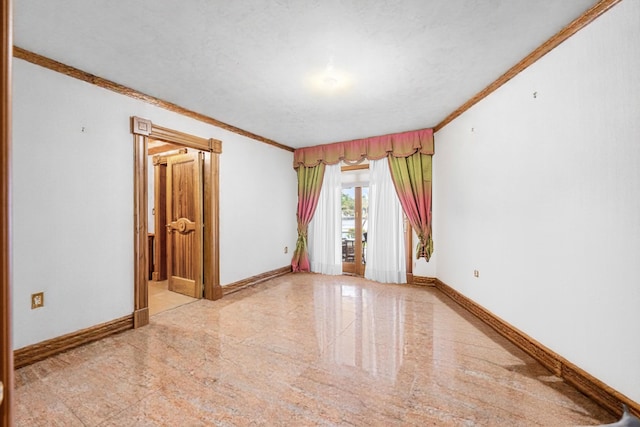 empty room with crown molding, granite finish floor, and baseboards