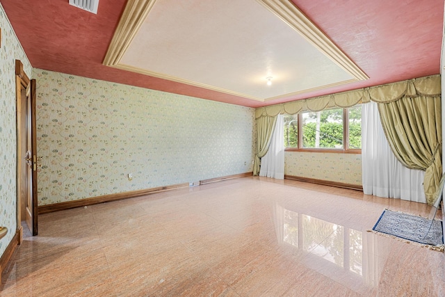 empty room with visible vents, baseboards, wallpapered walls, a raised ceiling, and crown molding