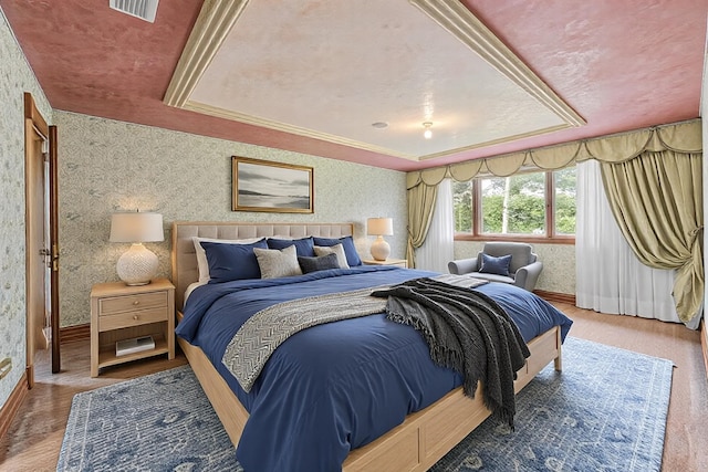 bedroom featuring wallpapered walls, visible vents, and a tray ceiling