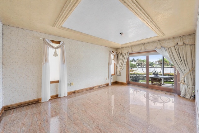 unfurnished room with wallpapered walls, granite finish floor, baseboards, and a raised ceiling