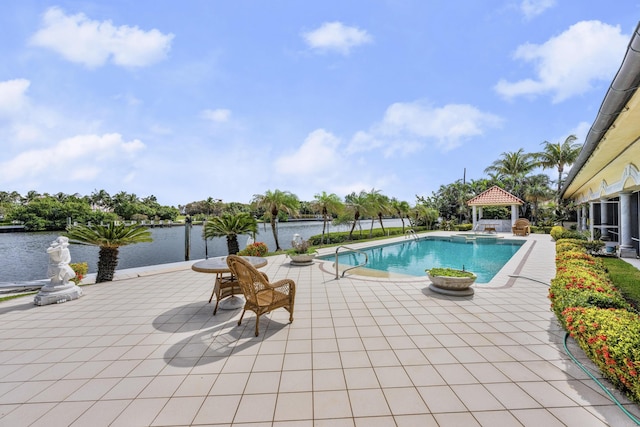 view of pool featuring a pool with connected hot tub, a patio area, a water view, and a gazebo