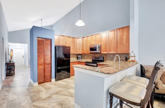 kitchen with high vaulted ceiling, light stone counters, stainless steel appliances, a peninsula, and decorative backsplash