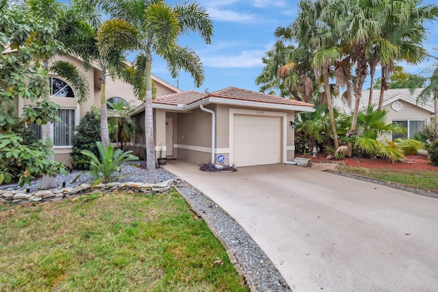 view of front of house featuring stucco siding, concrete driveway, an attached garage, and a tile roof