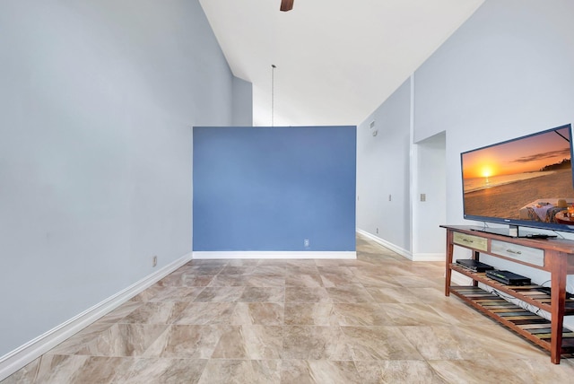 unfurnished living room with ceiling fan, baseboards, and high vaulted ceiling