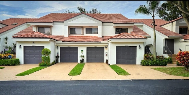 view of front facade featuring a tile roof, driveway, and stucco siding