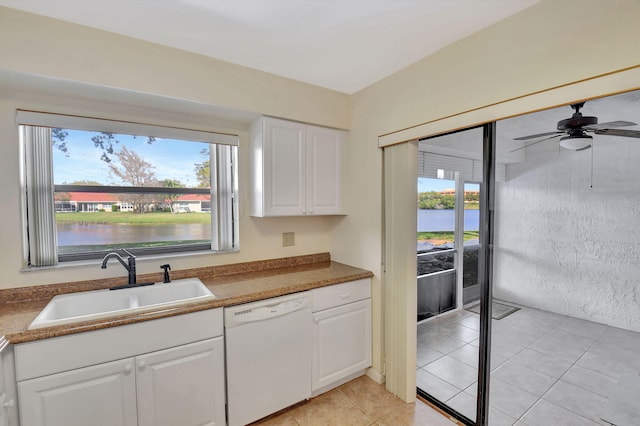 kitchen featuring white cabinets, a water view, white dishwasher, a healthy amount of sunlight, and a sink