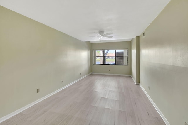 unfurnished room featuring ceiling fan, light wood-type flooring, visible vents, and baseboards