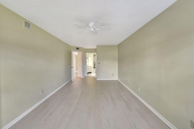 unfurnished room featuring light wood-style floors, baseboards, visible vents, and ceiling fan