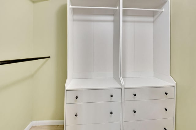 walk in closet with light wood-style floors