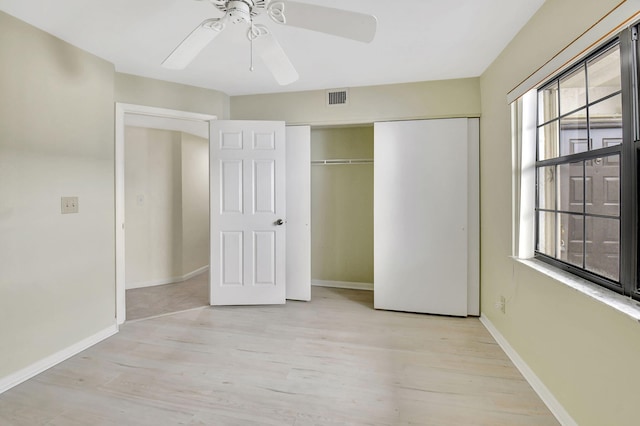 unfurnished bedroom featuring light wood finished floors, visible vents, baseboards, and a closet