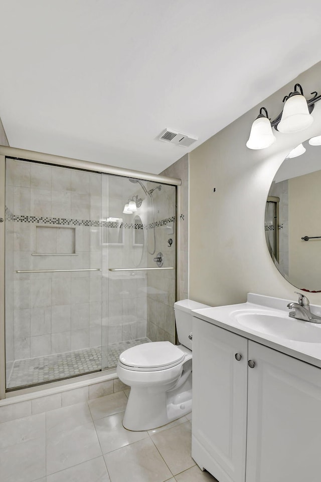 bathroom featuring a stall shower, visible vents, toilet, tile patterned floors, and vanity