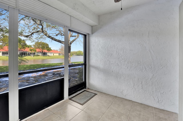 unfurnished sunroom featuring a water view