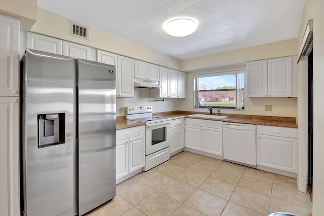 kitchen featuring under cabinet range hood, white appliances, a sink, visible vents, and white cabinets