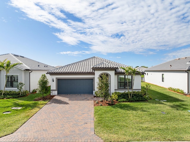 view of front facade with an attached garage, a front lawn, decorative driveway, and stucco siding