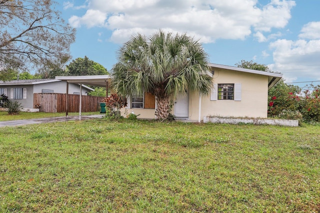 view of front of home with a front lawn, fence, and stucco siding