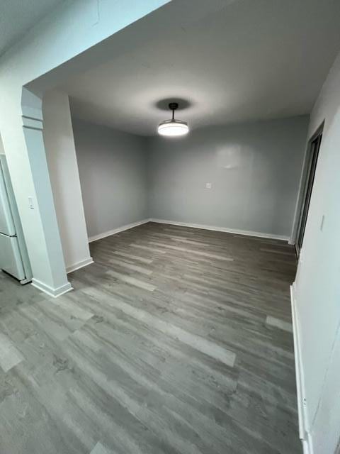 interior space featuring fridge, baseboards, and wood finished floors