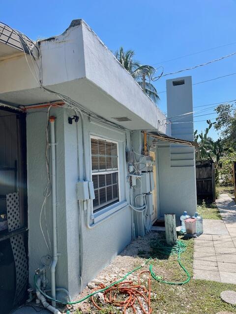 view of side of property featuring fence and stucco siding