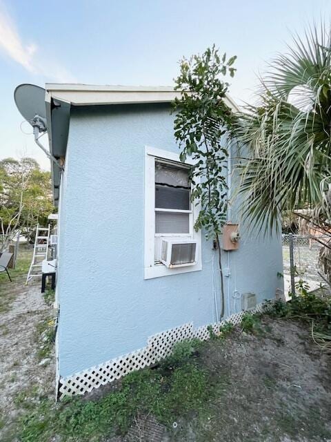 view of side of property with cooling unit and stucco siding