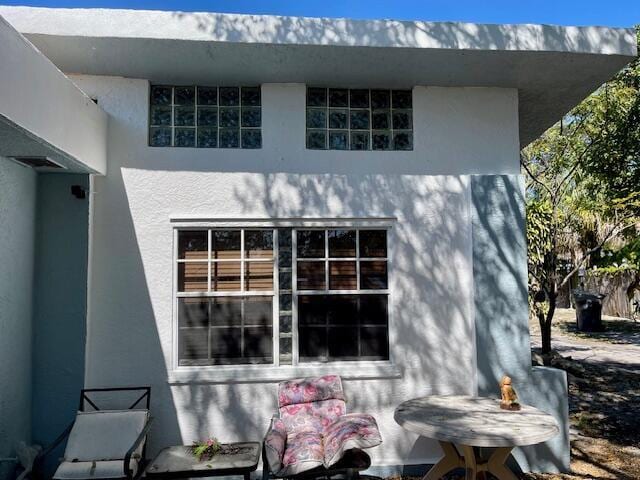 rear view of property featuring stucco siding