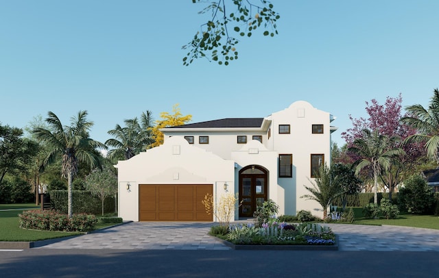 mediterranean / spanish home with a garage, decorative driveway, and stucco siding