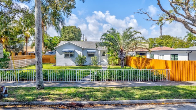 view of front of property featuring a fenced front yard, a front lawn, and stucco siding