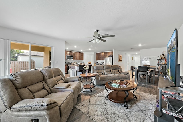 living room featuring dark wood-style floors, a ceiling fan, and recessed lighting