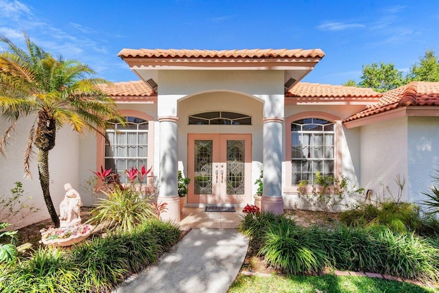 view of exterior entry featuring stucco siding and french doors