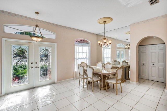 dining space featuring visible vents, french doors, arched walkways, light tile patterned flooring, and a chandelier