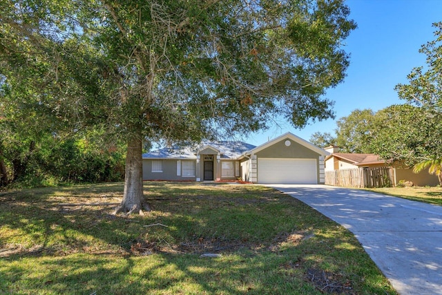 single story home with driveway, an attached garage, fence, a front lawn, and stucco siding