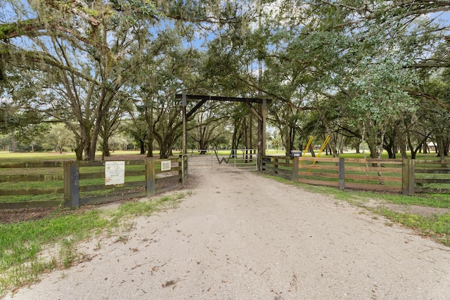 view of road featuring driveway, a gated entry, and a rural view