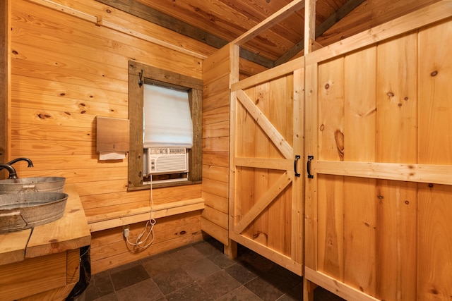 interior space featuring wood ceiling, a sink, and wooden walls