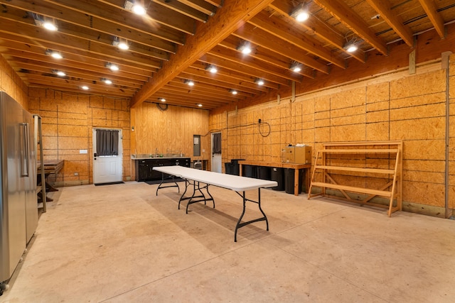 game room with wood walls and concrete flooring