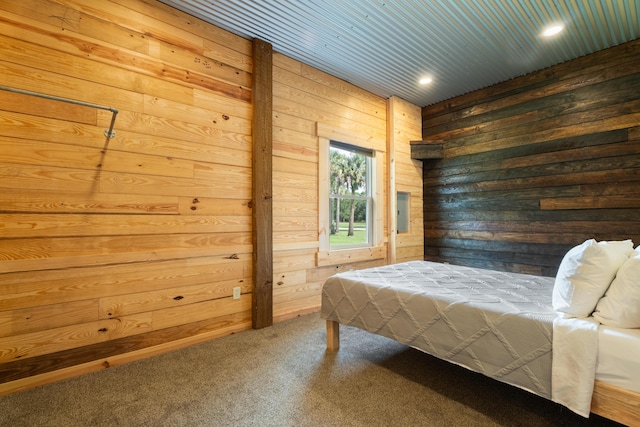 bedroom with carpet flooring and wooden walls