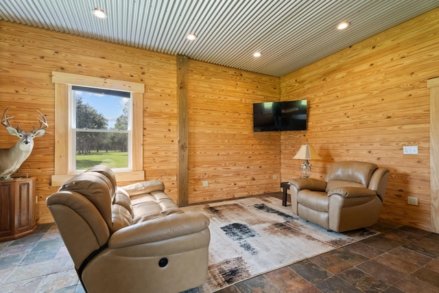 unfurnished living room featuring recessed lighting, stone tile flooring, and wooden walls