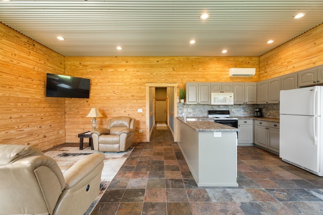 kitchen with gray cabinets, white appliances, stone finish flooring, and open floor plan