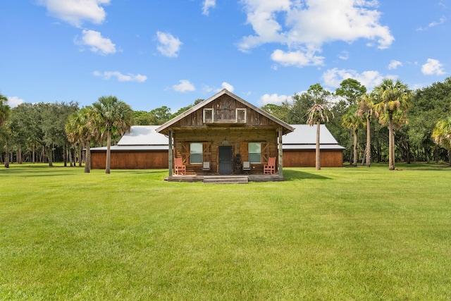 back of property featuring a lawn and an outdoor structure