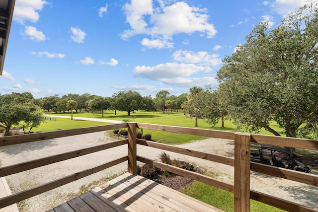 deck with view of golf course and an enclosed area