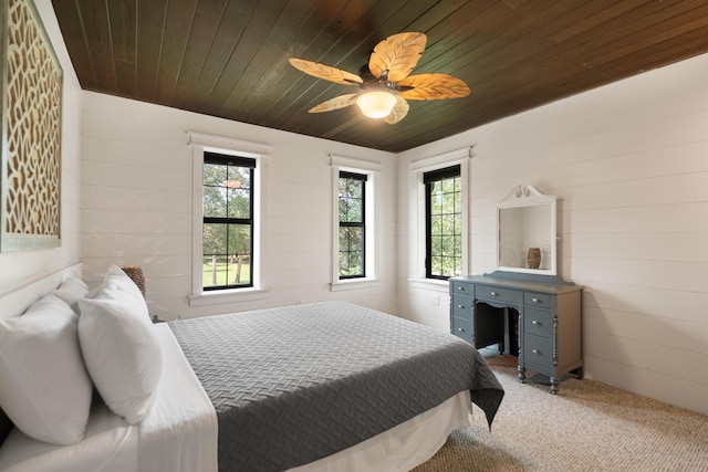 carpeted bedroom featuring a ceiling fan, wooden ceiling, and multiple windows