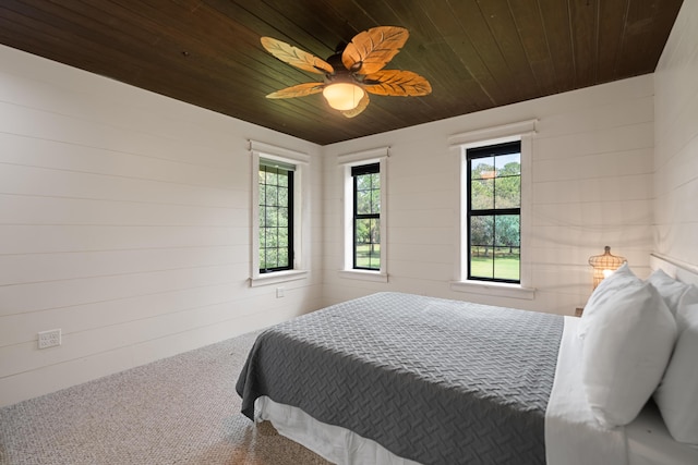 bedroom with a ceiling fan, wooden ceiling, and carpet flooring