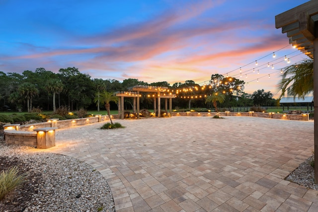 patio terrace at dusk featuring a pergola