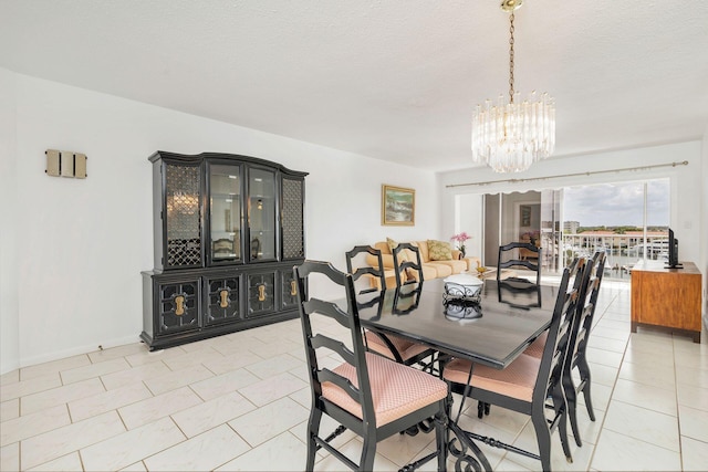 dining room with an inviting chandelier, light tile patterned floors, and a textured ceiling