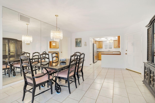 dining room with a chandelier, light tile patterned floors, and visible vents