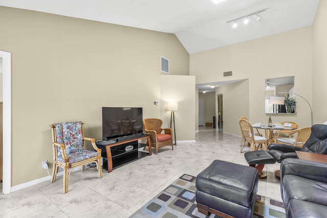 living room featuring high vaulted ceiling, rail lighting, visible vents, and baseboards