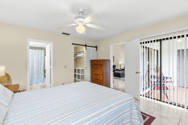 tiled bedroom featuring a barn door, visible vents, and a ceiling fan