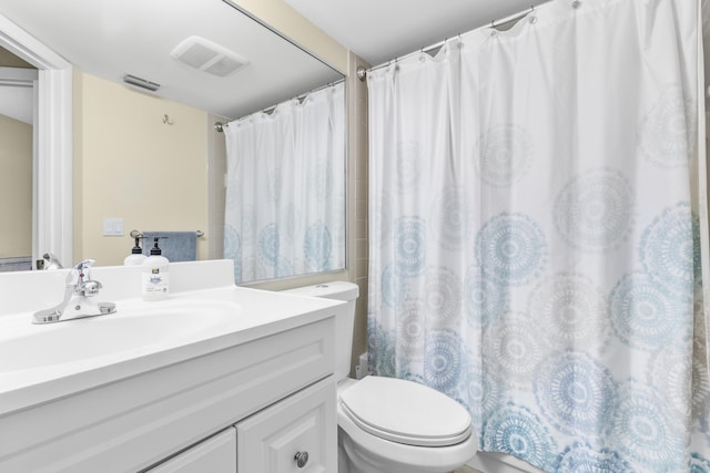 bathroom featuring toilet, a shower with curtain, visible vents, and vanity