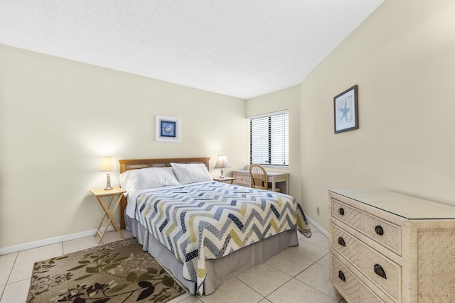 bedroom with a textured ceiling, baseboards, and light tile patterned floors