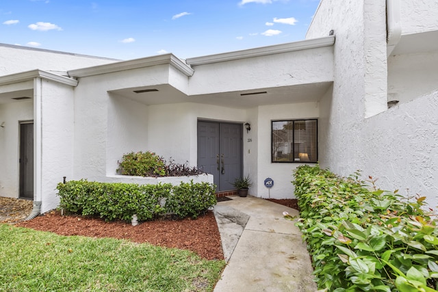 view of exterior entry with stucco siding