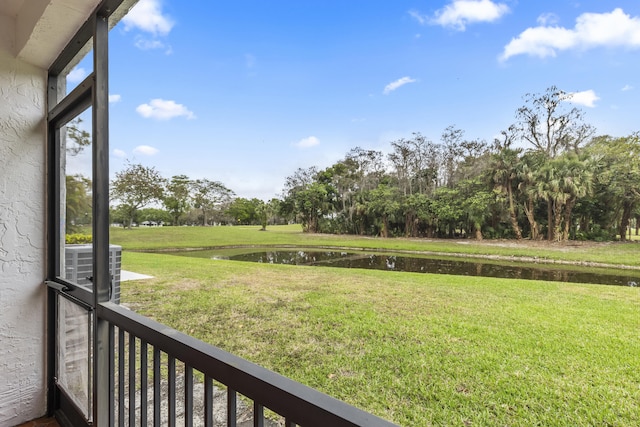 view of yard with a water view and central air condition unit