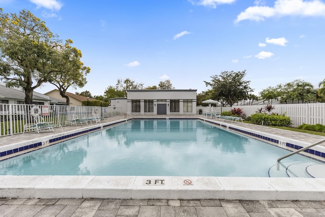 pool with a patio area and fence