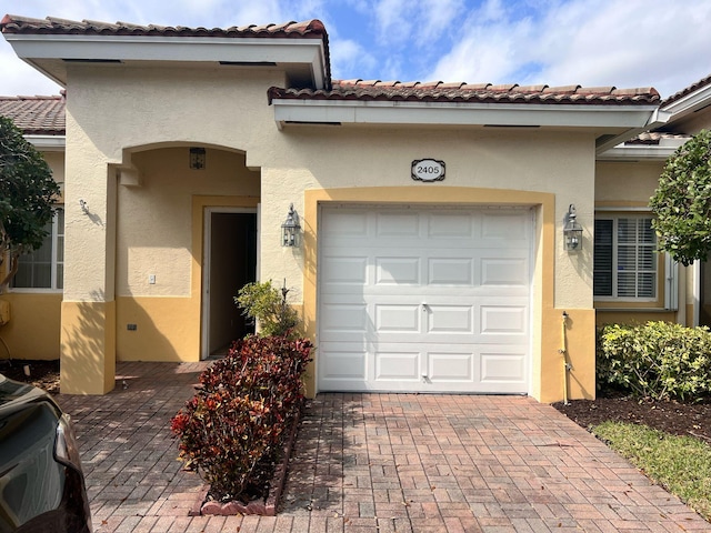 view of front of property with a garage, decorative driveway, and stucco siding